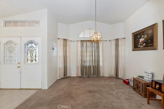 entrance foyer featuring carpet floors, high vaulted ceiling, and a chandelier