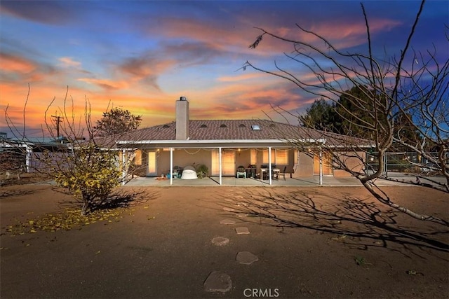 back house at dusk with a patio