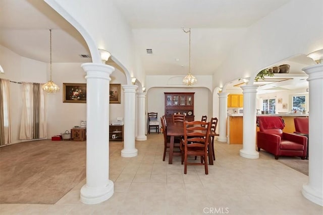 dining space with a notable chandelier, light colored carpet, and high vaulted ceiling