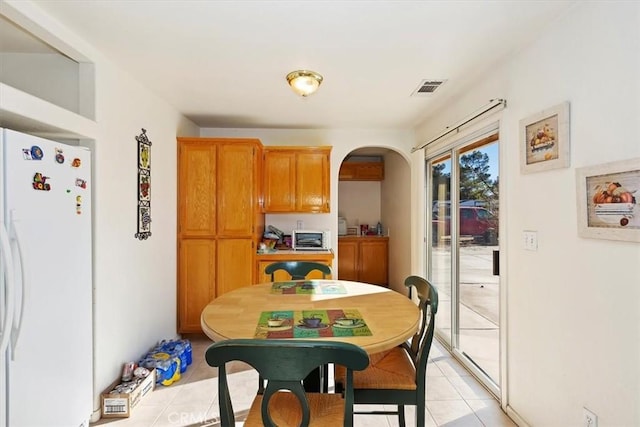 kitchen with light tile patterned floors and white fridge