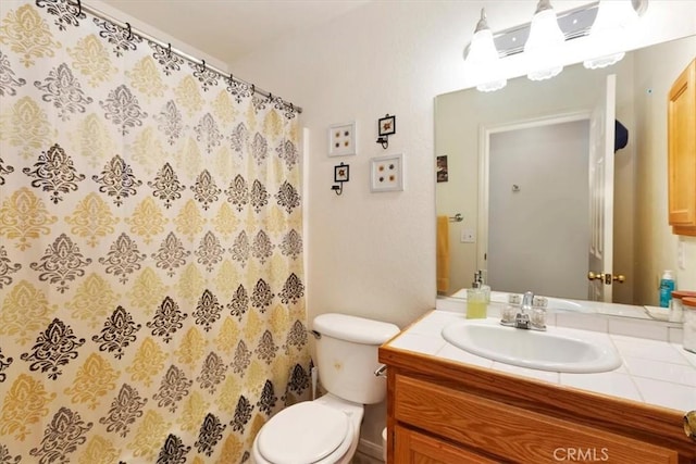 bathroom featuring vanity, toilet, and walk in shower