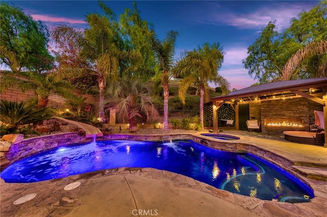 pool at dusk with an in ground hot tub, a patio area, a gazebo, and a water slide