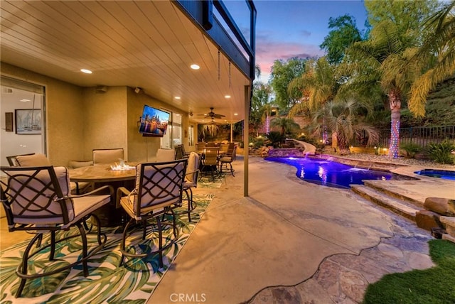 view of patio / terrace featuring a fenced in pool, ceiling fan, and pool water feature