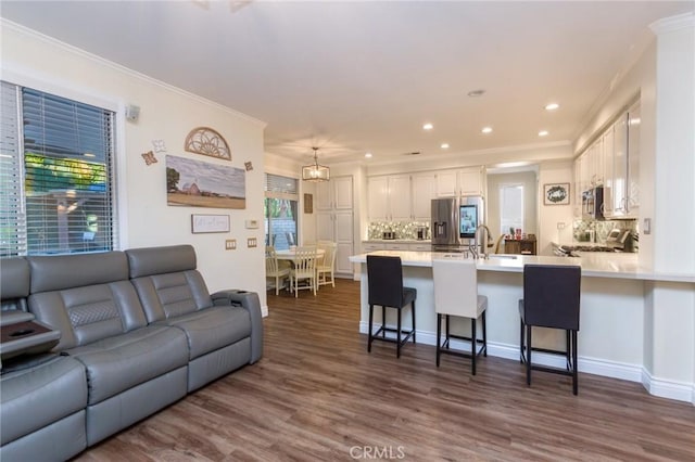 living room featuring dark hardwood / wood-style floors, sink, and ornamental molding