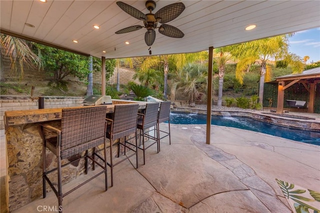 view of patio featuring an outdoor bar, area for grilling, a grill, pool water feature, and ceiling fan