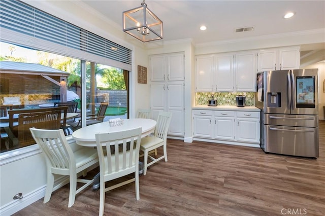 dining room with ornamental molding, a chandelier, and dark hardwood / wood-style floors