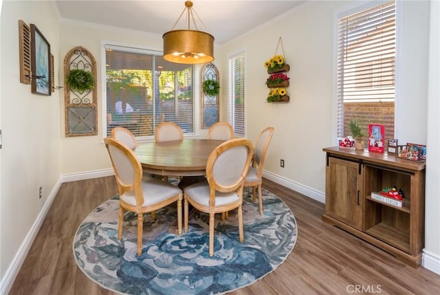 dining space featuring hardwood / wood-style flooring and crown molding