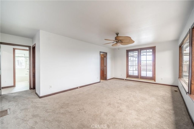 empty room featuring light colored carpet and ceiling fan