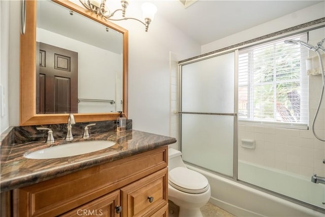 full bathroom featuring vanity, a healthy amount of sunlight, toilet, and shower / bath combination with glass door