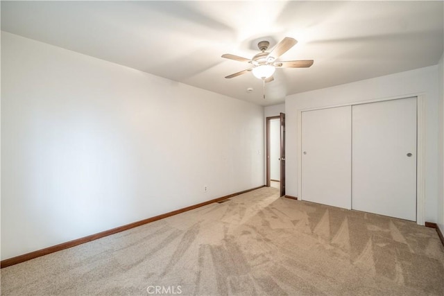 unfurnished bedroom featuring a closet, ceiling fan, and light colored carpet