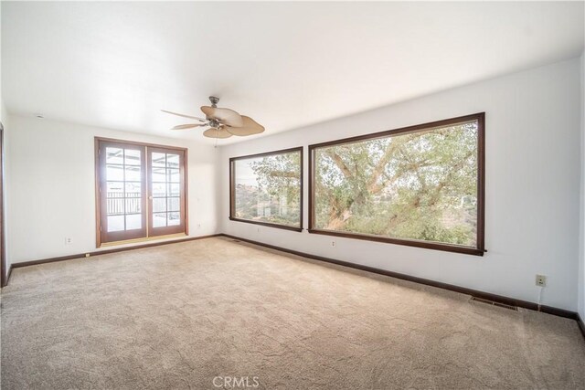 spare room with ceiling fan and light colored carpet