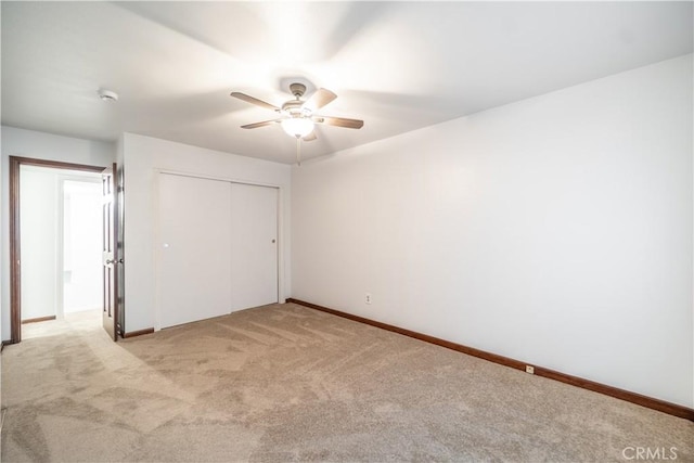 unfurnished bedroom featuring ceiling fan, light colored carpet, and a closet