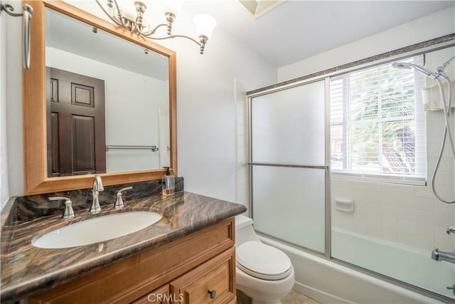 full bathroom featuring combined bath / shower with glass door, vanity, and toilet