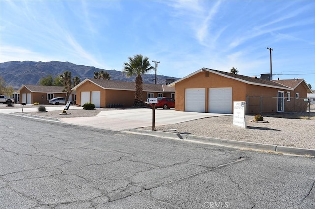 6424 Athol Ave Unit 29, Palms, CA 92277 - ranch-style house with an attached garage, a mountain view, stucco siding, fence, and concrete driveway