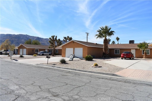 6424 Athol Ave Unit 29, Palms, CA 92277 - ranch-style house featuring driveway, stucco siding, an attached garage, and a mountain view