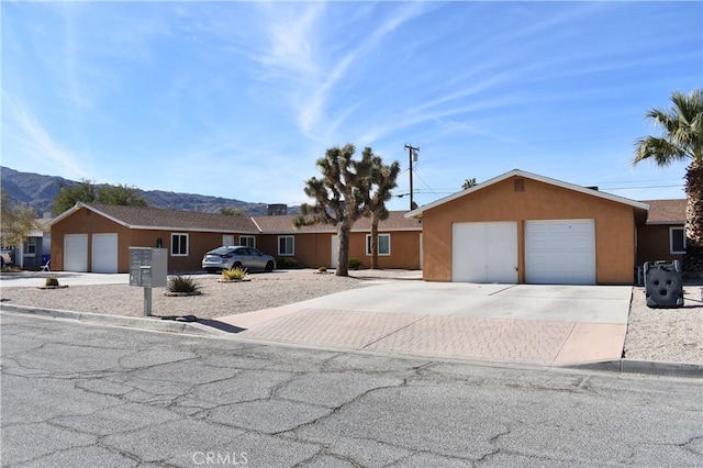 6424 Athol Ave Unit 29, Palms, CA 92277 - single story home featuring a mountain view, stucco siding, driveway, and a garage