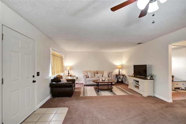 living room featuring carpet flooring, ceiling fan, and a textured ceiling