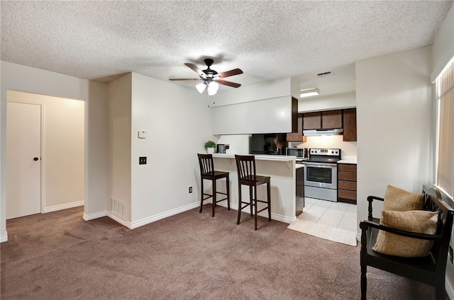 3504 Rainbow Ln, Highland, CA 92346 - kitchen featuring appliances with stainless steel finishes, light colored carpet, a kitchen bar, ceiling fan, and a textured ceiling