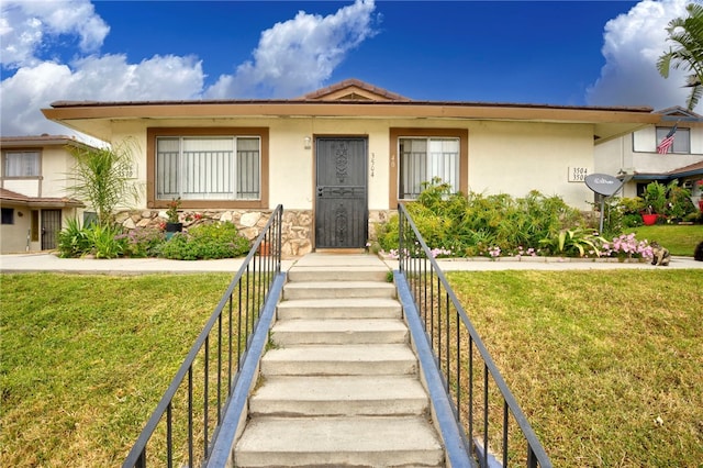 3504 Rainbow Ln, Highland, CA 92346 - view of front of property featuring stucco siding, a front lawn, and stone siding