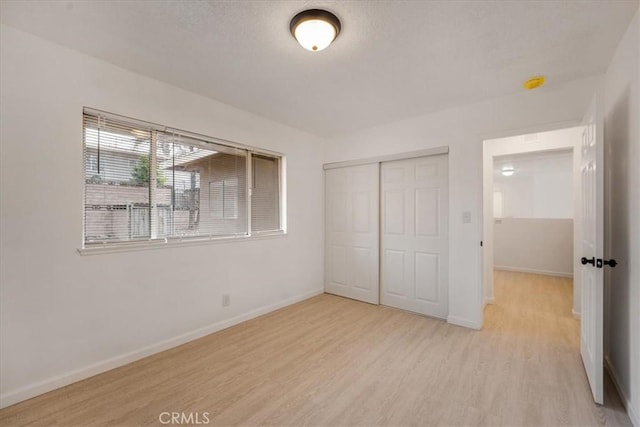 unfurnished bedroom featuring light hardwood / wood-style flooring and a closet