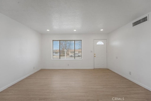 foyer with a textured ceiling and light wood-type flooring