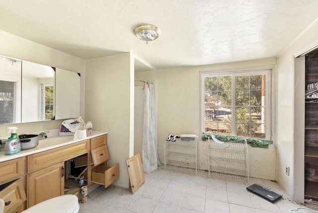 bathroom with tile patterned flooring, vanity, and walk in shower