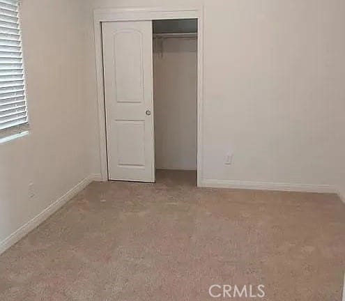 unfurnished bedroom with carpet and a closet