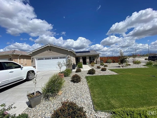 ranch-style home featuring a front yard, solar panels, and a garage