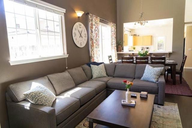 living room with a wealth of natural light, hardwood / wood-style floors, and an inviting chandelier