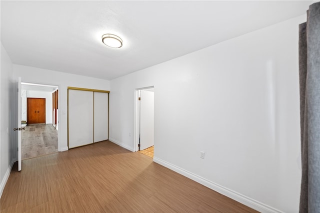 unfurnished bedroom with a closet and light hardwood / wood-style flooring