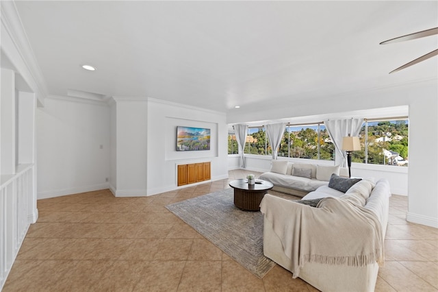 tiled living room with ceiling fan and ornamental molding