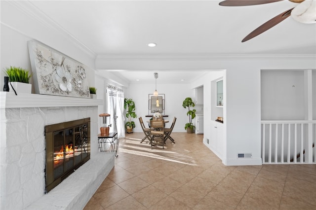 living room with ceiling fan and ornamental molding