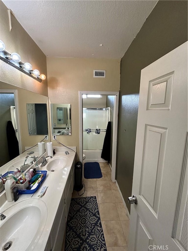 bathroom featuring tile patterned floors, vanity, a textured ceiling, and walk in shower