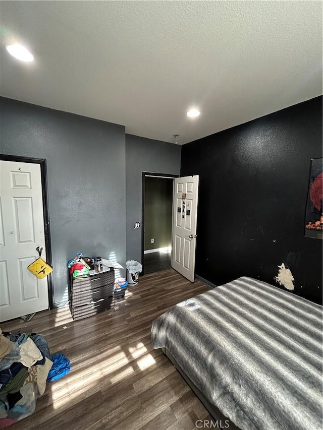 bedroom featuring a textured ceiling and dark wood-type flooring