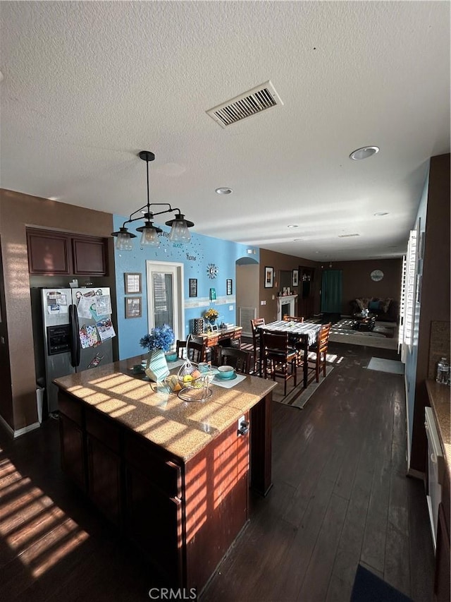 kitchen featuring stainless steel fridge with ice dispenser, dark hardwood / wood-style floors, a textured ceiling, dark brown cabinetry, and a chandelier