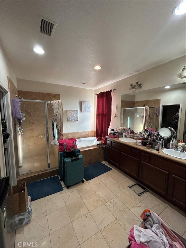 bathroom featuring a textured ceiling, vanity, and shower with separate bathtub