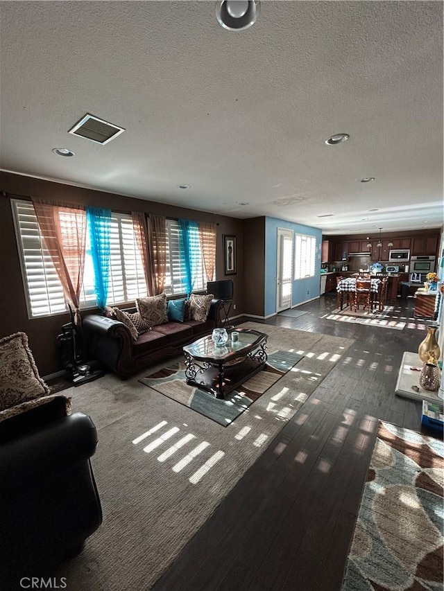 living room featuring a textured ceiling and dark hardwood / wood-style floors