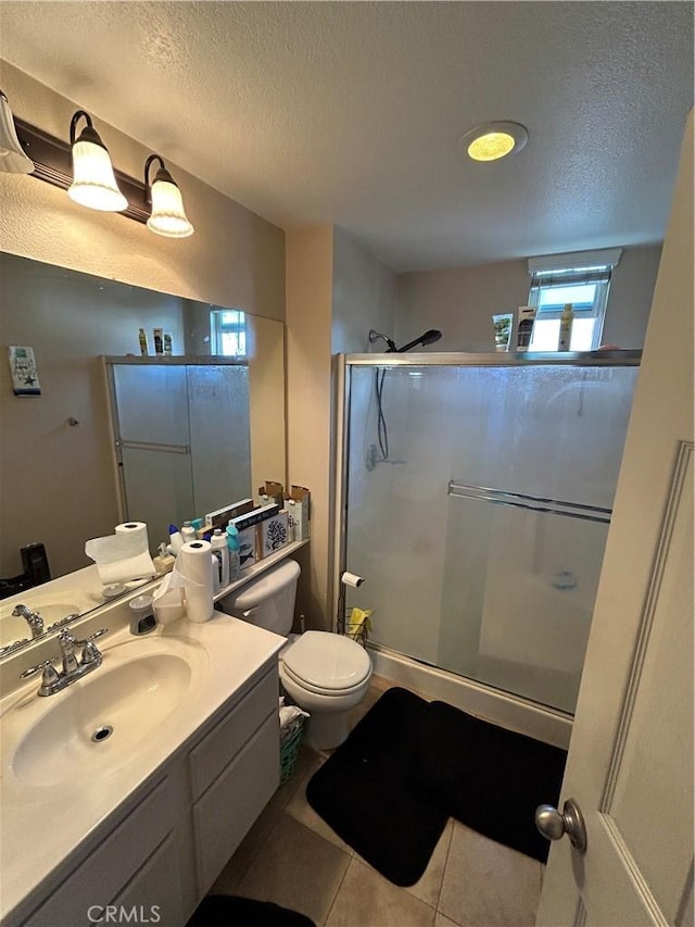 bathroom featuring vanity, tile patterned floors, toilet, a textured ceiling, and an enclosed shower