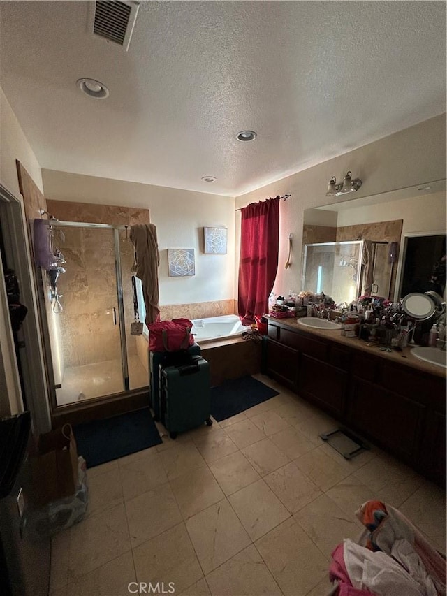 bathroom with plus walk in shower, vanity, and a textured ceiling