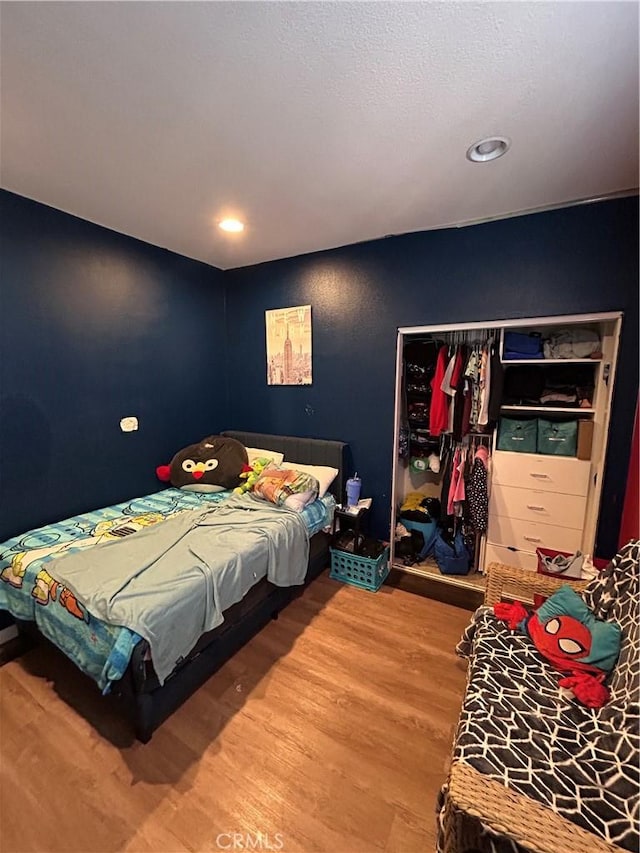 bedroom with wood-type flooring and a closet