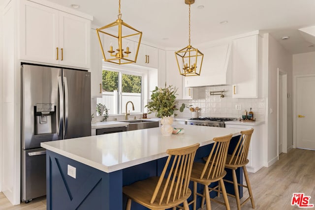 kitchen featuring white cabinetry, sink, a kitchen island, and appliances with stainless steel finishes