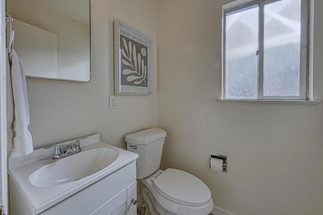 bathroom featuring toilet, a healthy amount of sunlight, and vanity