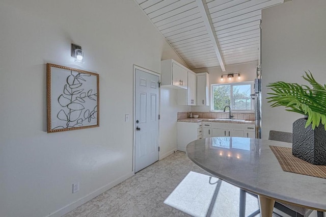 kitchen featuring lofted ceiling with beams, wood ceiling, sink, and white cabinetry