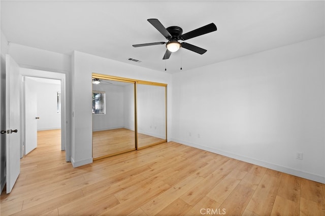 unfurnished bedroom with ceiling fan, a closet, and light hardwood / wood-style floors