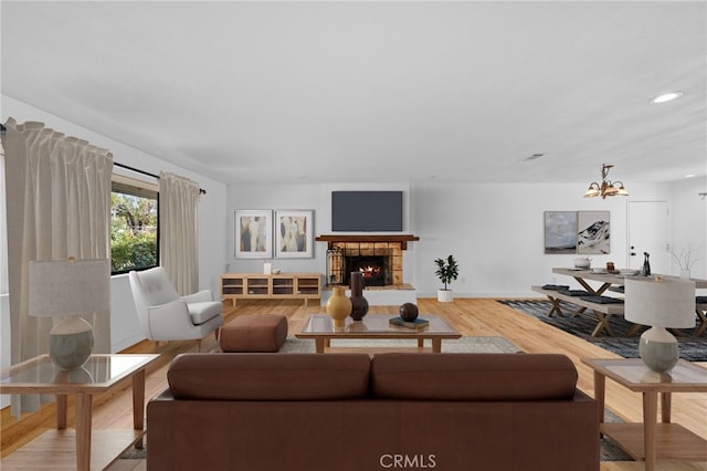 living room featuring hardwood / wood-style floors, a fireplace, and an inviting chandelier