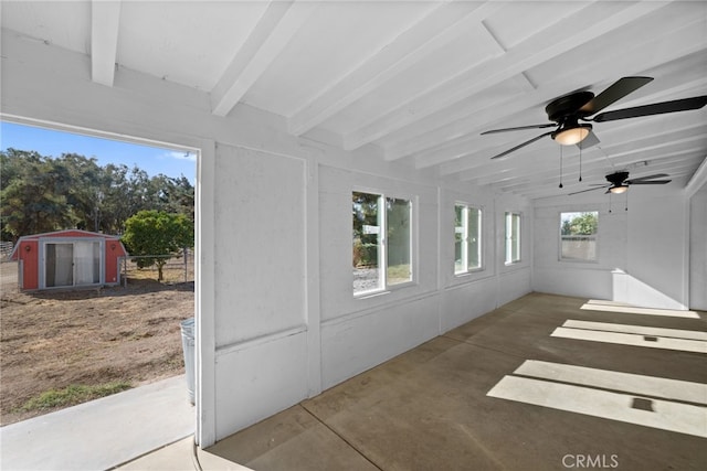 unfurnished sunroom with vaulted ceiling with beams and ceiling fan