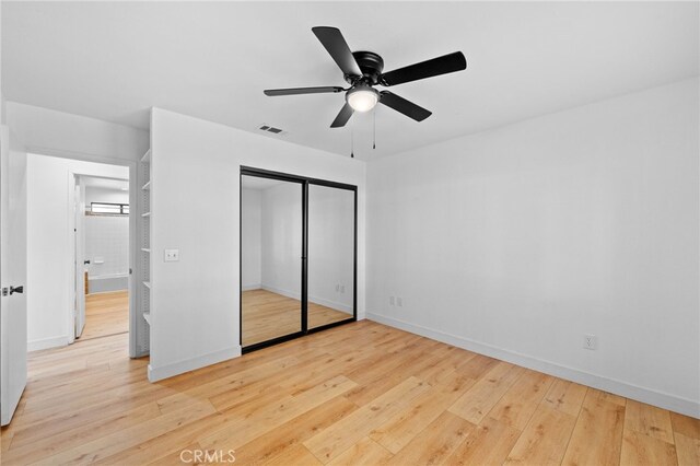 unfurnished bedroom with ceiling fan, a closet, and light wood-type flooring