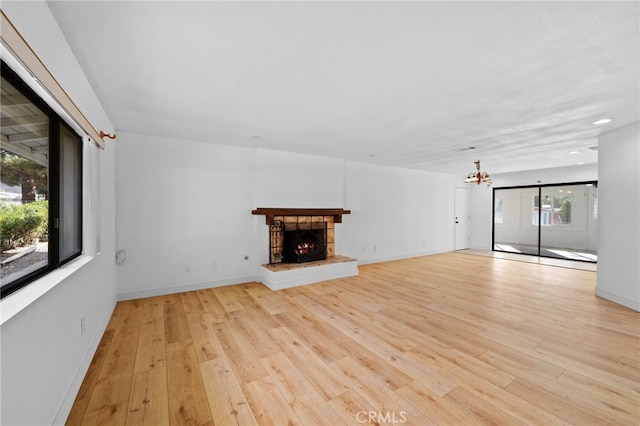 unfurnished living room with a chandelier and light hardwood / wood-style flooring