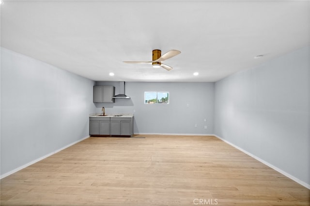 unfurnished room featuring ceiling fan, light hardwood / wood-style flooring, and sink