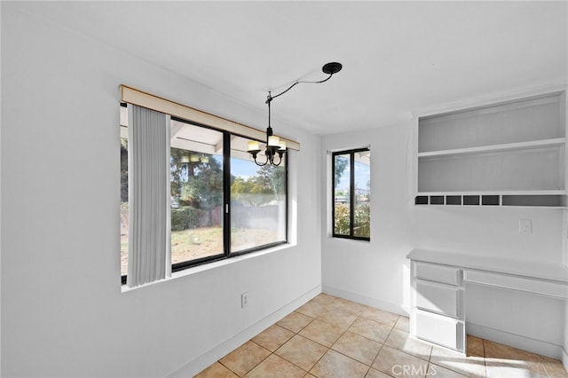 unfurnished dining area with light tile patterned floors and a chandelier